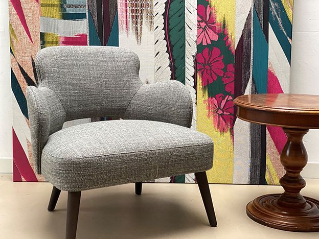 Ein Stuhl und ein Tisch vor einem farbenfrohen Gemälde