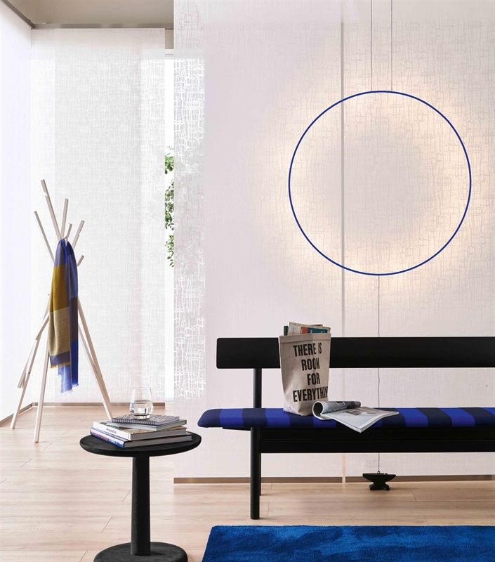 Ein Wohnzimmer mit einer schwarzen Bank und einem blauen Teppich