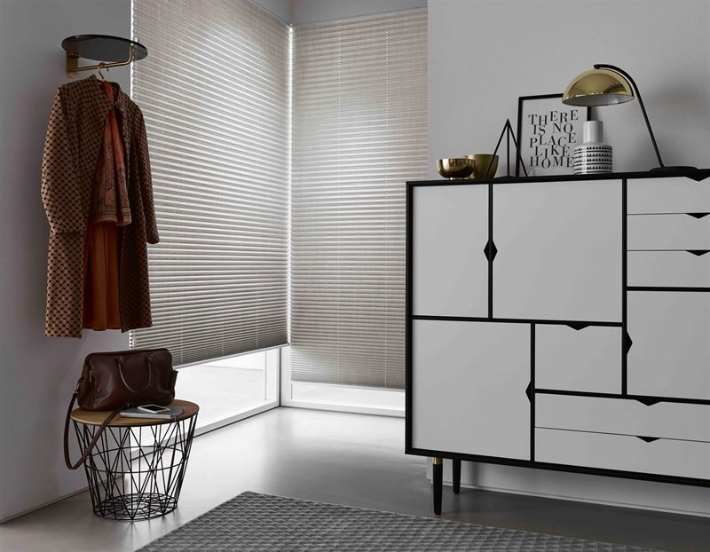 Ein Zimmer mit einer Kommode und einem an der Wand hängenden Mantel