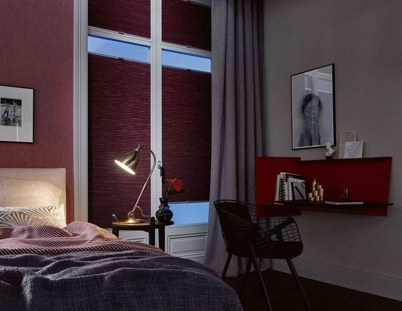 Ein Schlafzimmer mit einem Bett, einem Schreibtisch und einer Lampe