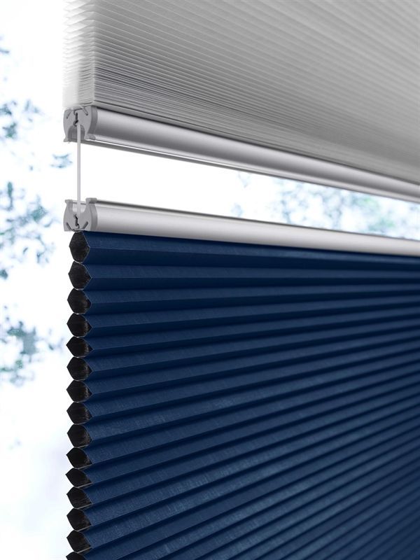 Eine Nahaufnahme einer blau-weißen Jalousie an einem Fenster