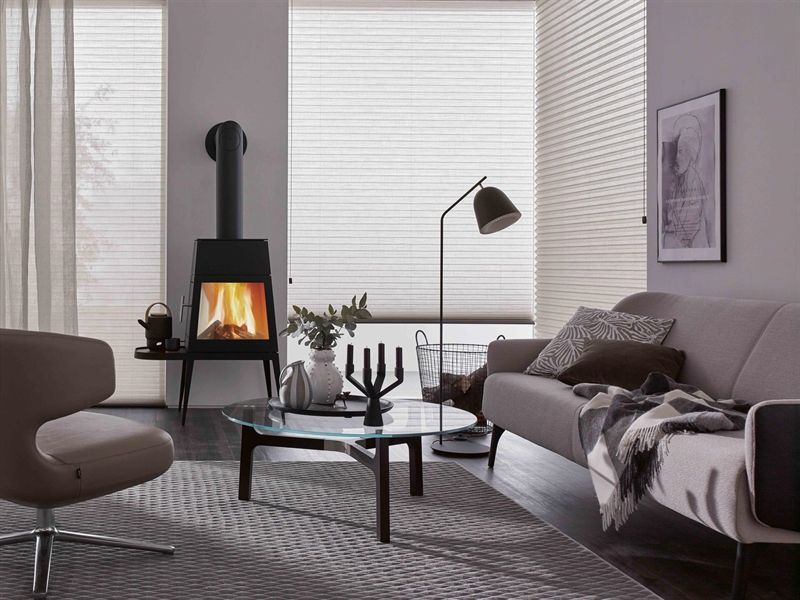 Ein Wohnzimmer mit einer Couch, einem Sessel und einem Kamin