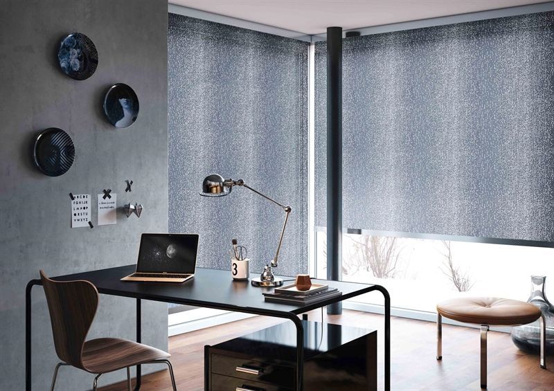 Ein Schreibtisch mit einem Laptop darauf in einem Zimmer