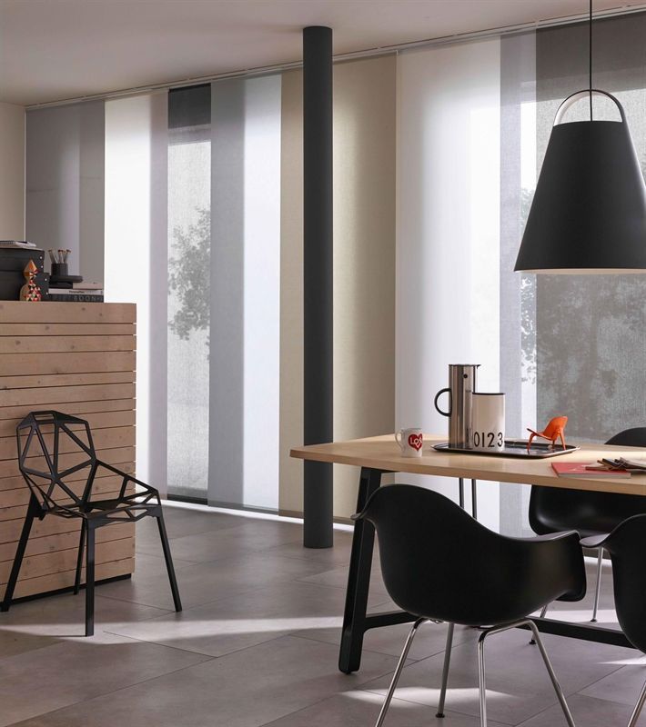 Ein Esszimmer mit Tisch und Stühlen und einer Lampe