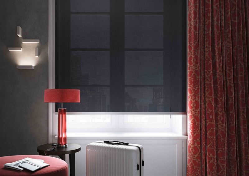 Ein Zimmer mit einer Lampe und einem Koffer vor einem Fenster