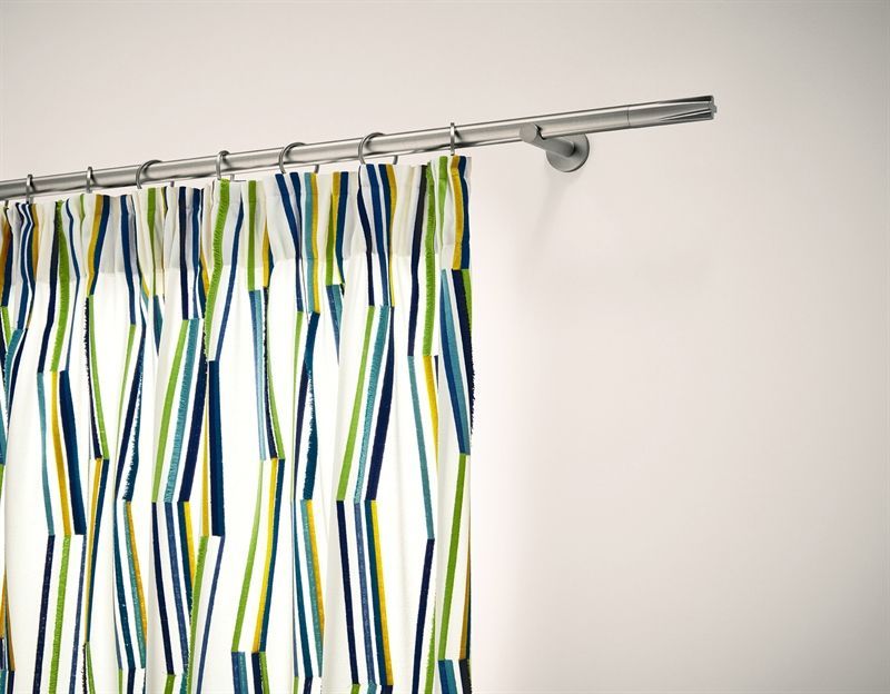 Ein Vorhang mit blau-grünen und gelben Streifen hängt an einer weißen Wand