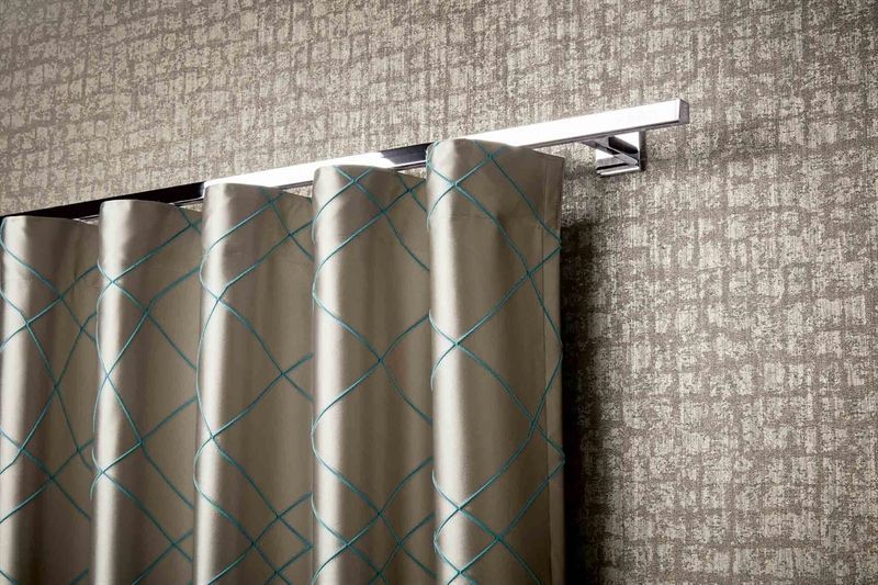 Eine Nahaufnahme eines Paars Vorhänge, die an einer Wand hängen.