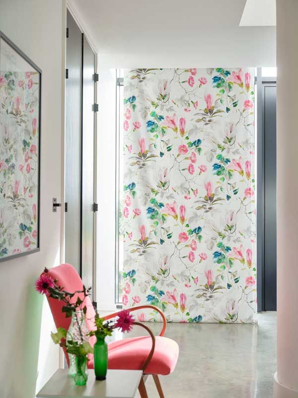 Ein Flur mit einem rosa Stuhl und Blumen auf einem Tisch