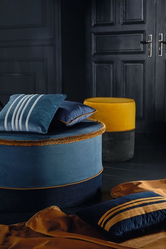 Ein Zimmer mit blauen und gelben Kissen und Ottomanen