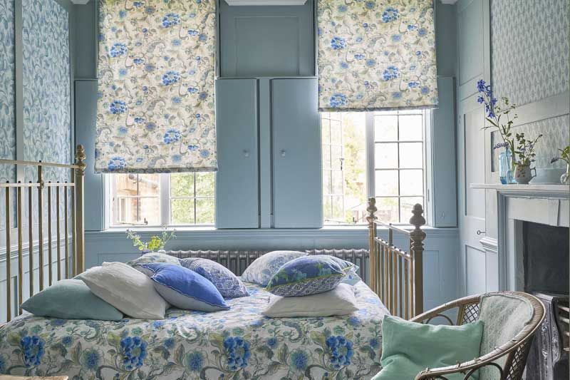 Ein Schlafzimmer mit Bett, Stuhl, Fenster und Kamin.