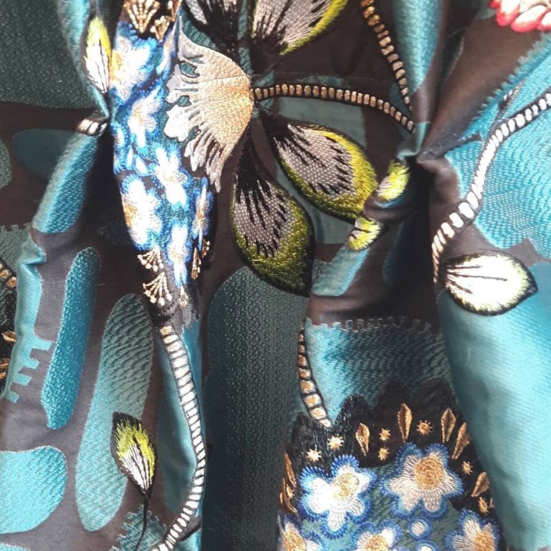 Eine Nahaufnahme eines Stoffes mit Blumen und Blättern darauf