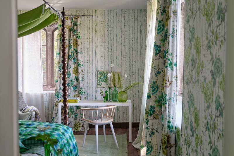 Ein Schlafzimmer mit grünen Vorhängen und einem Himmelbett