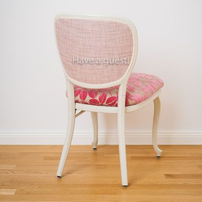 Die Rückenlehne eines Stuhls mit der Aufschrift „Have a Guest“ darauf