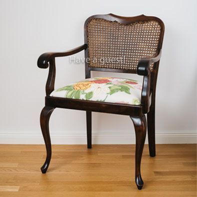 Ein Stuhl mit Korbrücken steht auf einem Holzboden