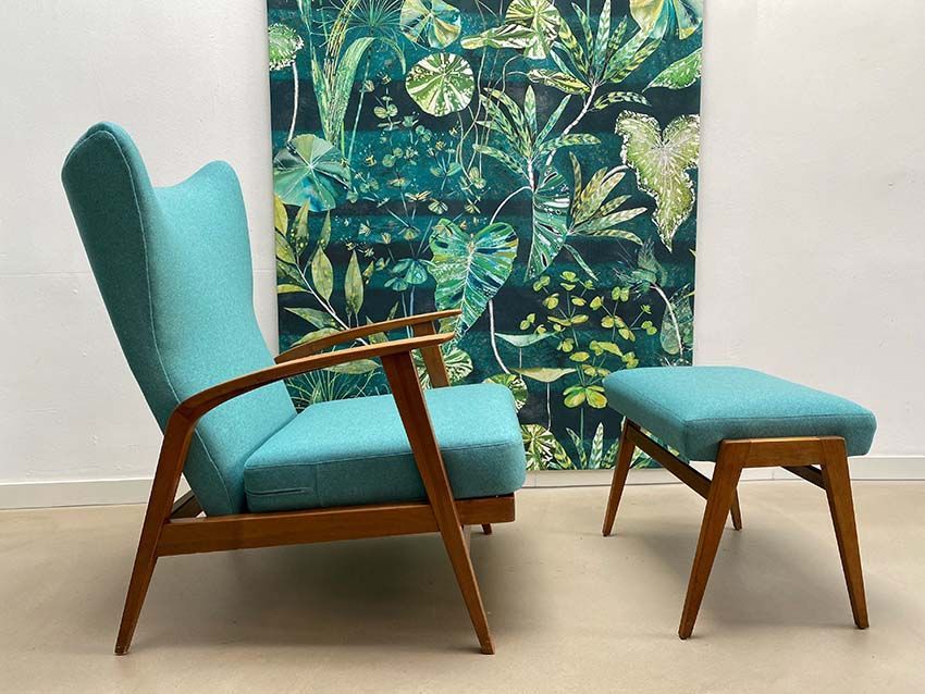 Ein Stuhl und ein Ottoman vor einem Gemälde