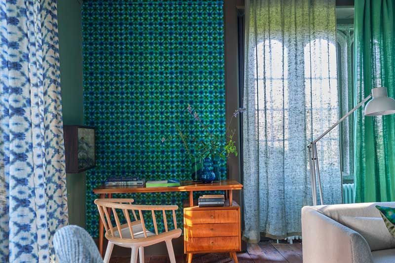 Ein Wohnzimmer mit grünen Vorhängen und einem Schreibtisch