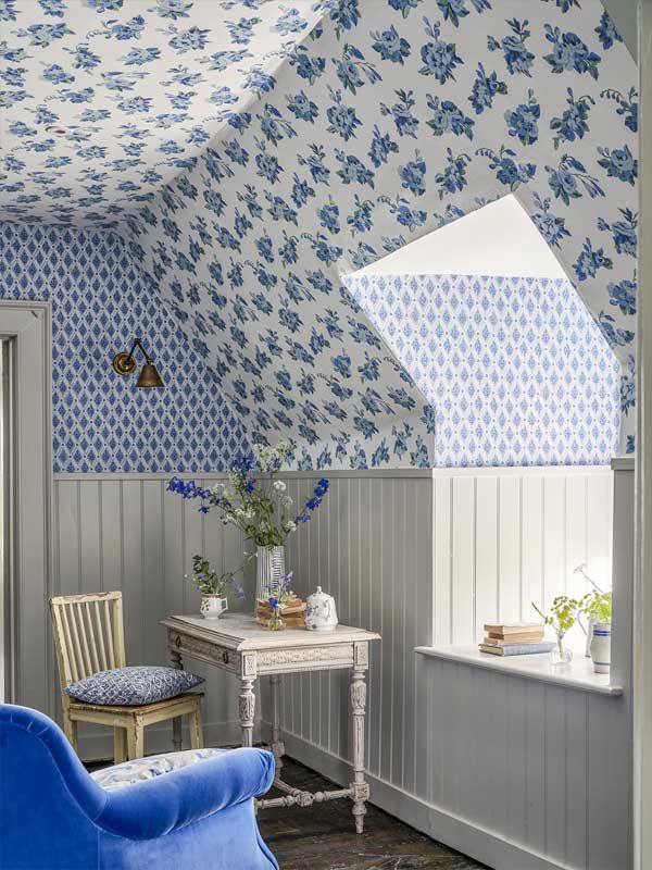 Ein Zimmer mit blau-weißer Blumentapete an der Decke