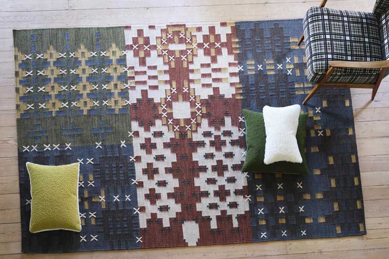 Ein Stuhl steht neben einem Teppich auf dem Boden