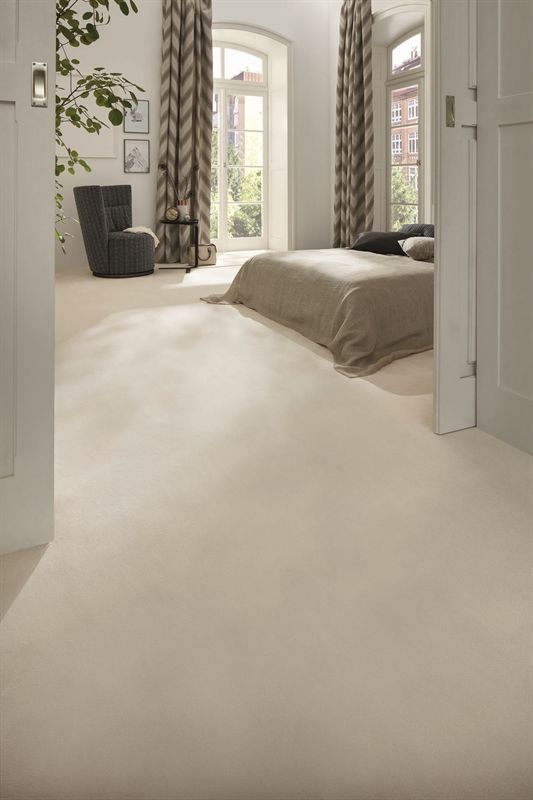 Ein Schlafzimmer mit Bett, Stuhl und Fenster.