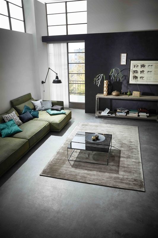 Ein Wohnzimmer mit einer grünen Sofagarnitur und einem Couchtisch.