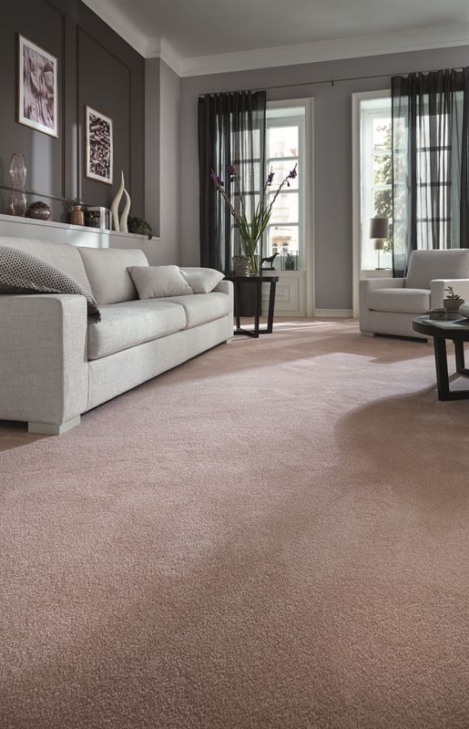 Ein Wohnzimmer mit einer Couch und Stühlen und einem rosa Teppich