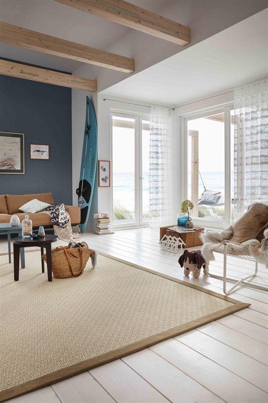 Ein Wohnzimmer mit einer Couch, einem Sessel und einem Teppich