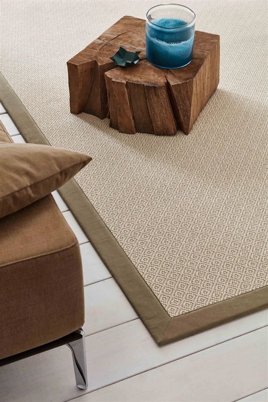 Ein Glas mit blauer Flüssigkeit steht auf einem Holzblock auf einem Teppich