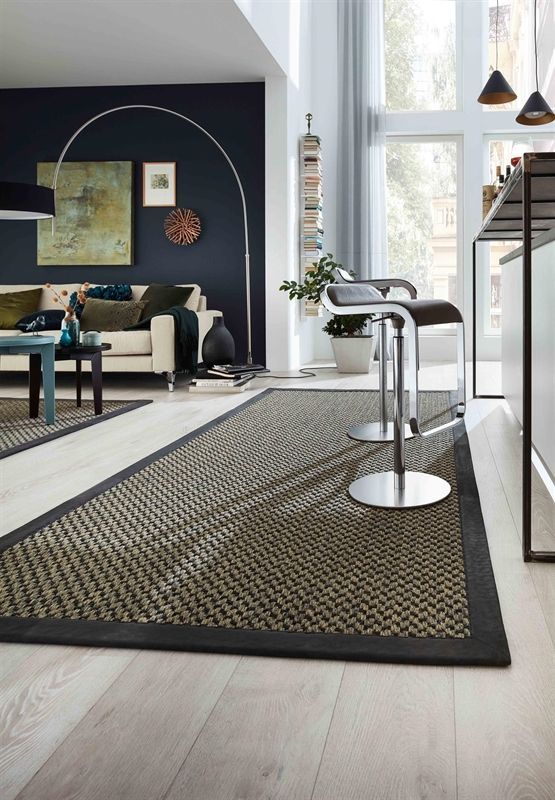 Ein Wohnzimmer mit einem Teppich und einer Couch