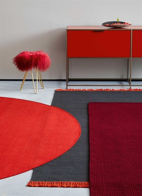 Ein roter Hocker steht neben einem roten Schrank