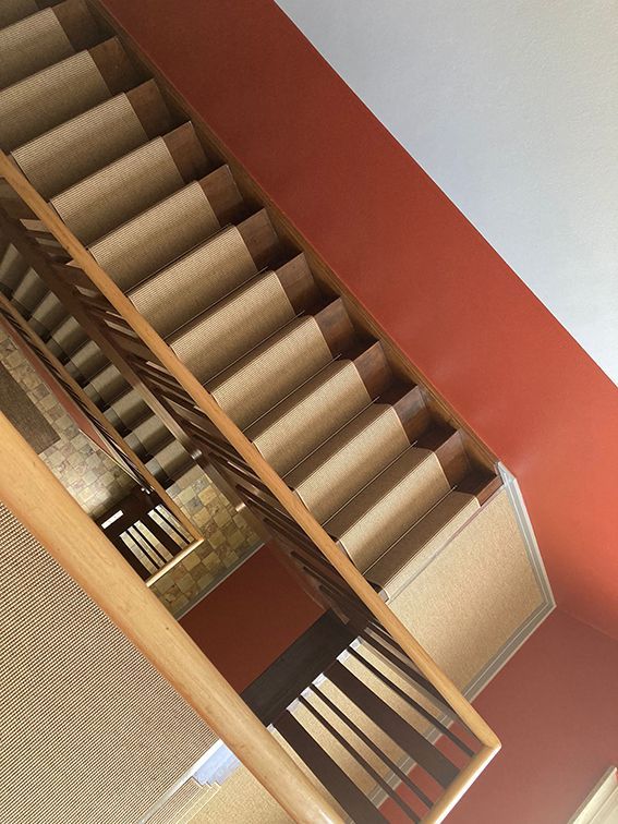 Eine Treppe mit Holzgeländer und mit Teppich ausgelegten Stufen