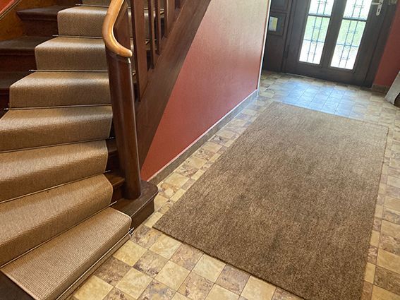 Eine Treppe mit einem Teppich auf dem Boden daneben