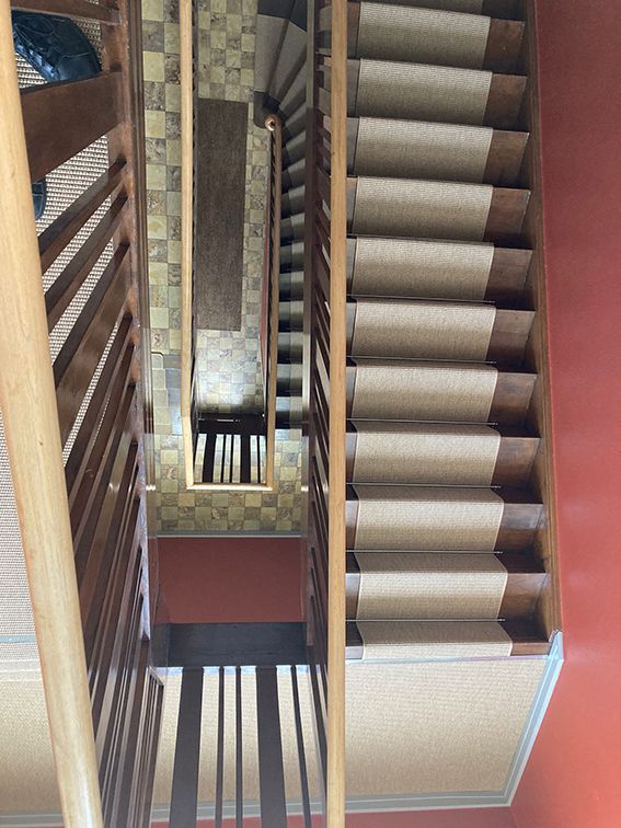 Eine Treppe mit Holzgeländer und mit Teppich ausgelegten Stufen