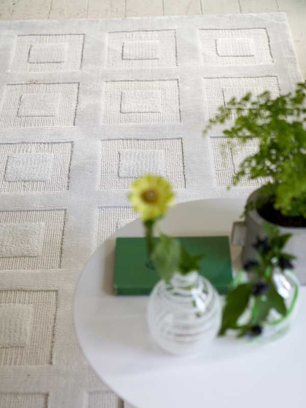 Ein Tisch mit einer Blumenvase und einem Buch darauf.