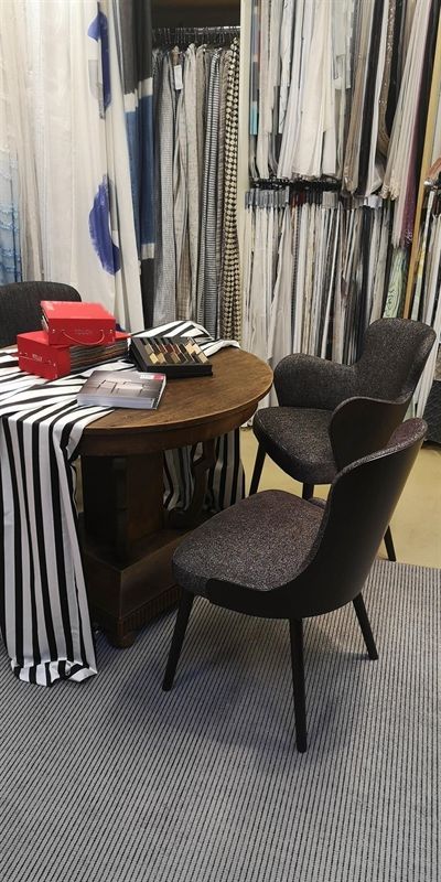 Ein Tisch und Stühle in einem Raum mit einer gestreiften Tischdecke.