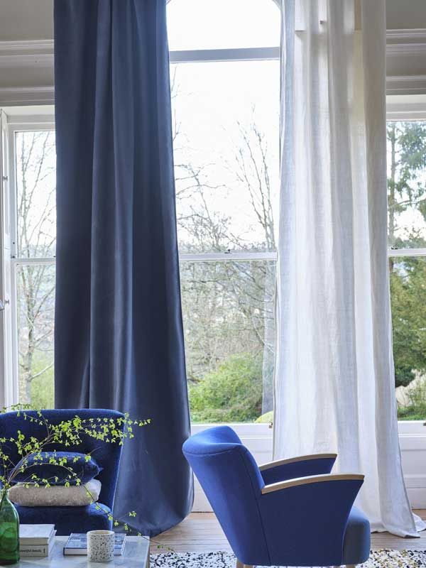 Ein Wohnzimmer mit blauen Vorhängen und einem blauen Stuhl