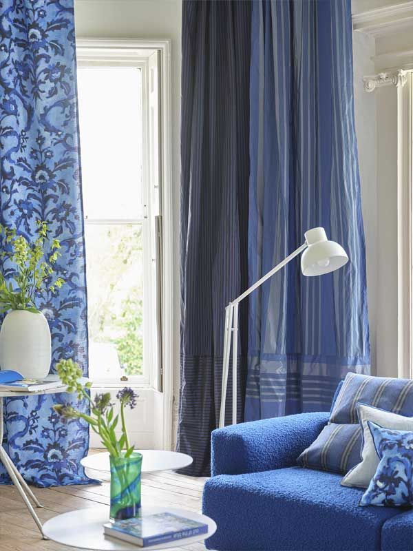 Ein Wohnzimmer mit einer blauen Couch und blauen Vorhängen