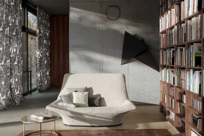 Ein Wohnzimmer mit einer Couch und einem Bücherregal voller Bücher.