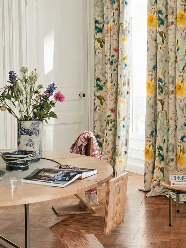 Ein Tisch mit einer Vase mit Blumen darauf in einem Wohnzimmer