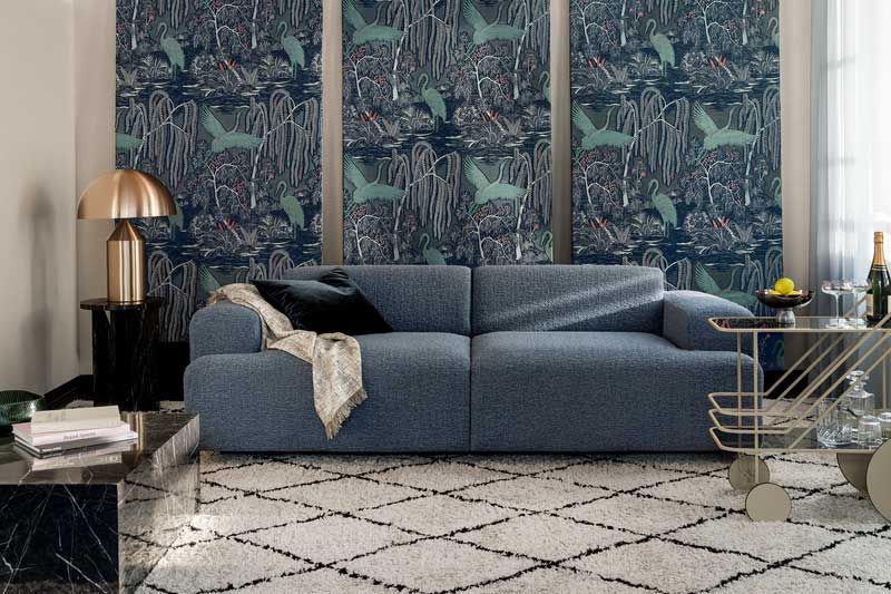 Ein Wohnzimmer mit einer blauen Couch und einem weißen Teppich