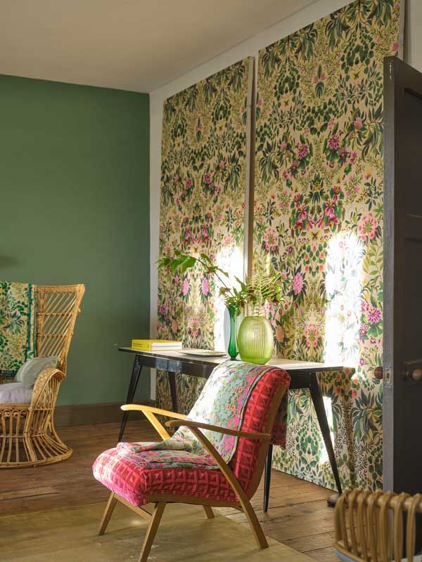 Ein Wohnzimmer mit grünen Wänden und einem roten Stuhl
