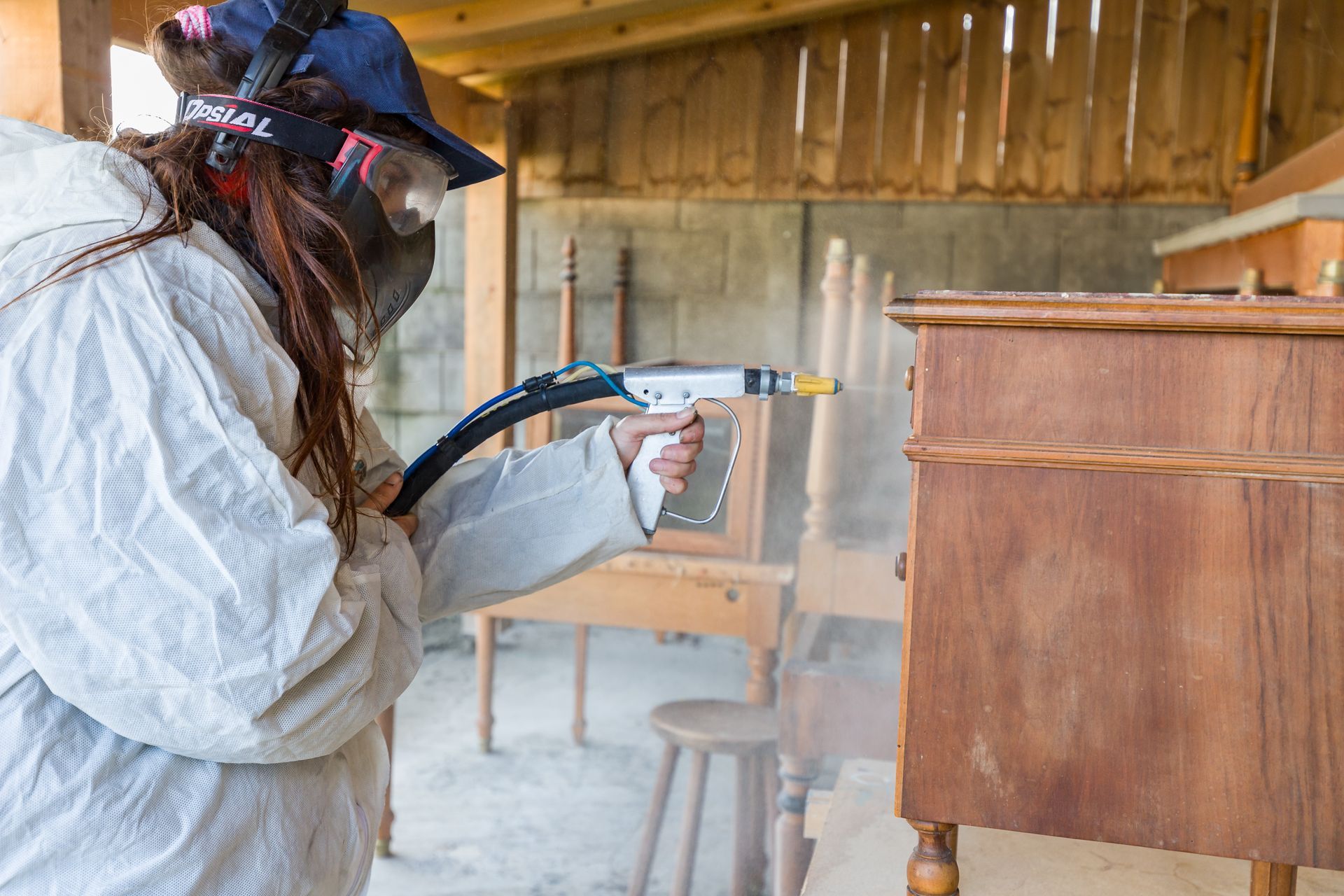 Professionnelle d'EMPLOI PLURI-SERVICES rénovant un meuble