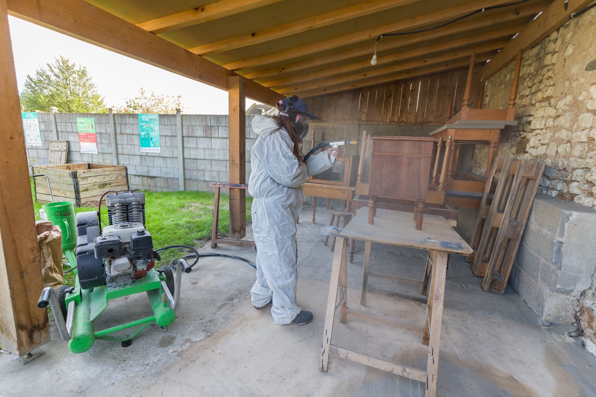 Professionnelle d'EMPLOI PLURI-SERVICES en combinaison rénovant un meuble