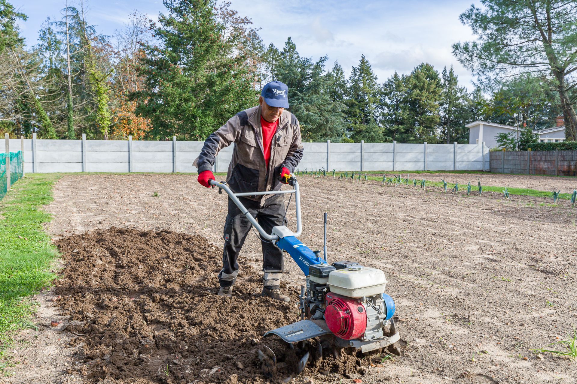 Professionnel d'EMPLOI PLURI-SERVICES passant une machine dans un champ pour labourer