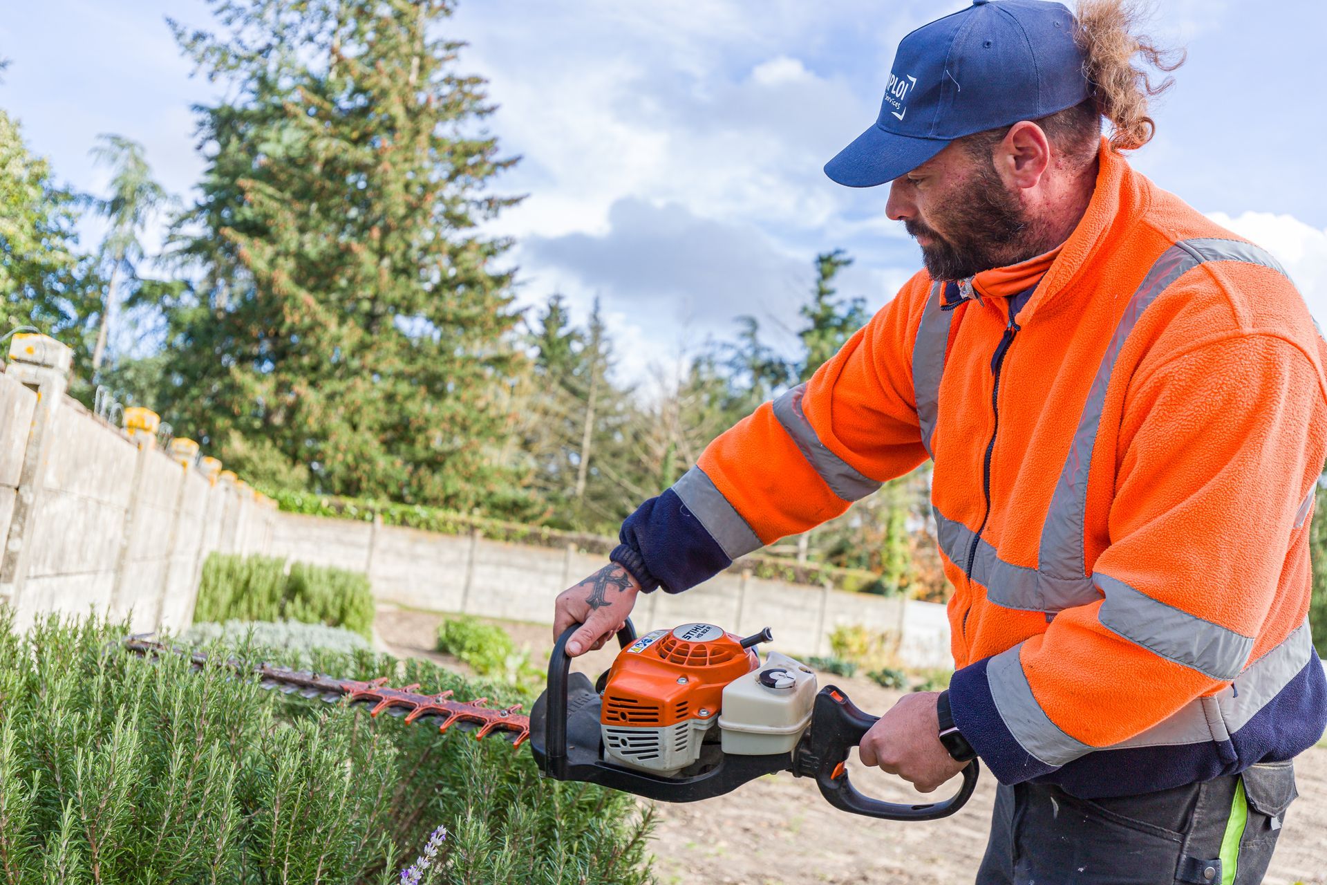 Professionnel d'EMPLOI PLURI-SERVICES taillant la haie d'un jardin