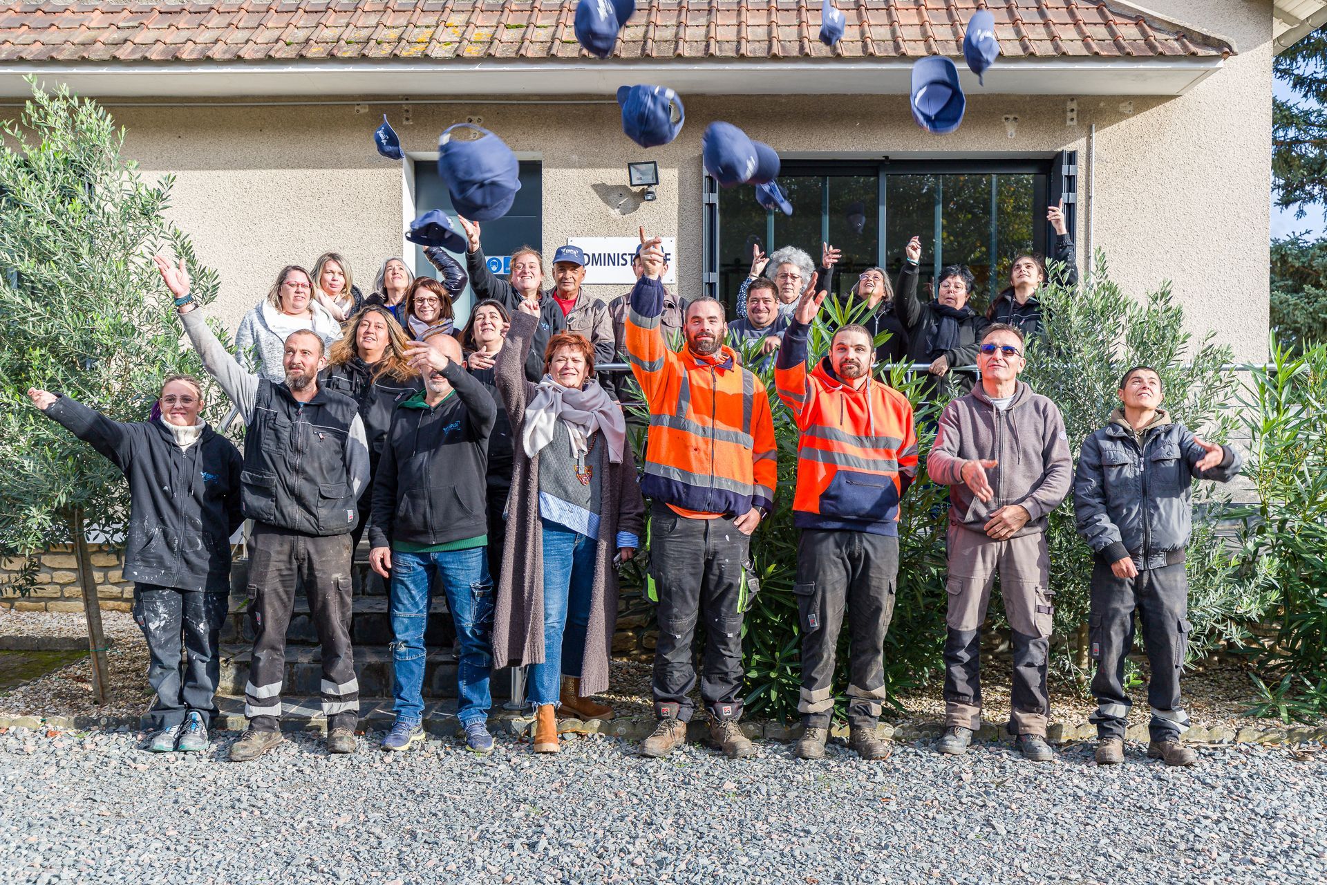 Équipe entière d'EMPLOI PLURI-SERVICES qui jette des casquettes en l'air