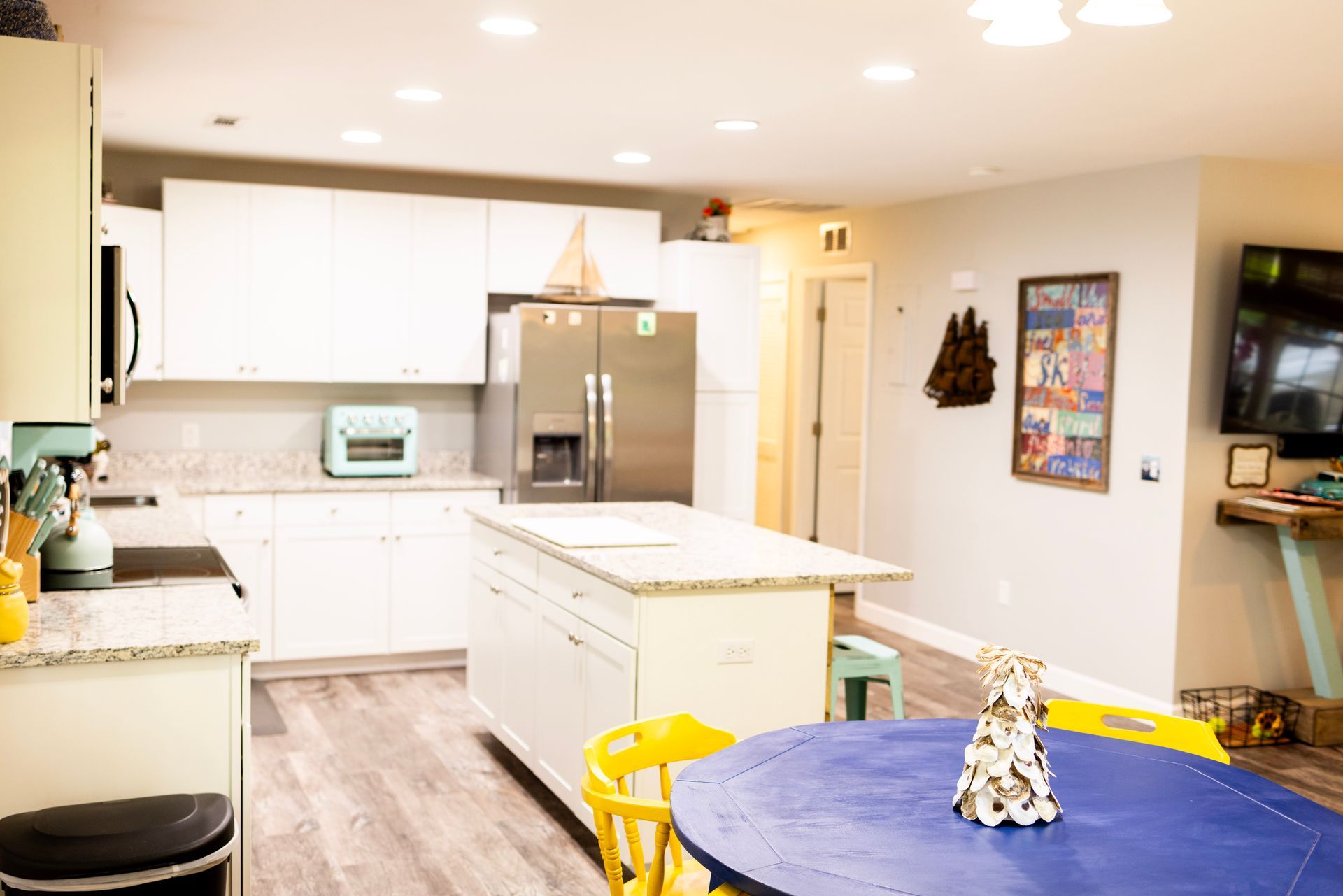 A kitchen with a blue table and yellow chairs