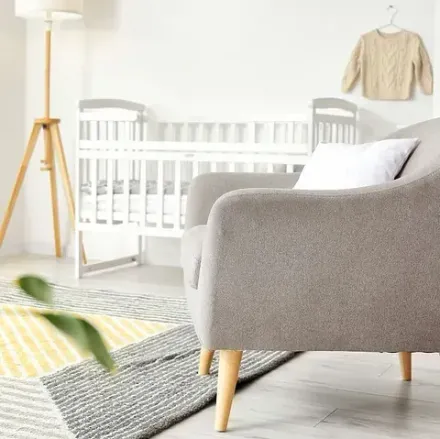 Una sala de estar con una silla y una cuna.