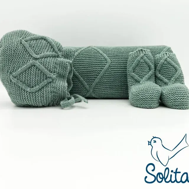 Un par de calcetines de punto y una manta con la palabra solita en la parte inferior.