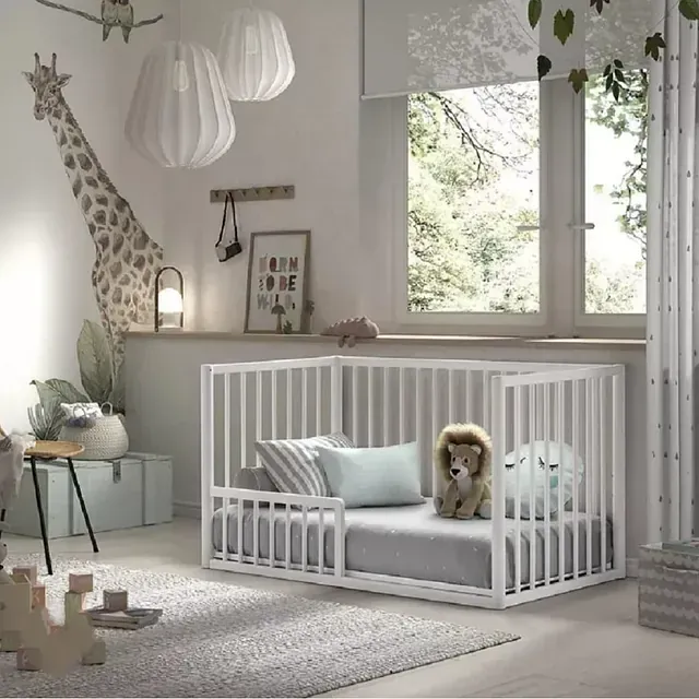 Una habitación con una cuna y una jirafa en la pared.