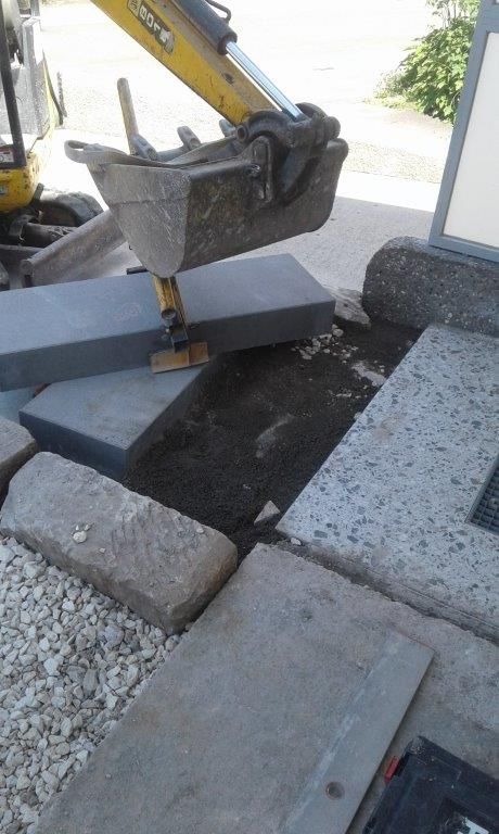 Ein Hausmodell ist von Bauplänen und Bäumen umgeben.